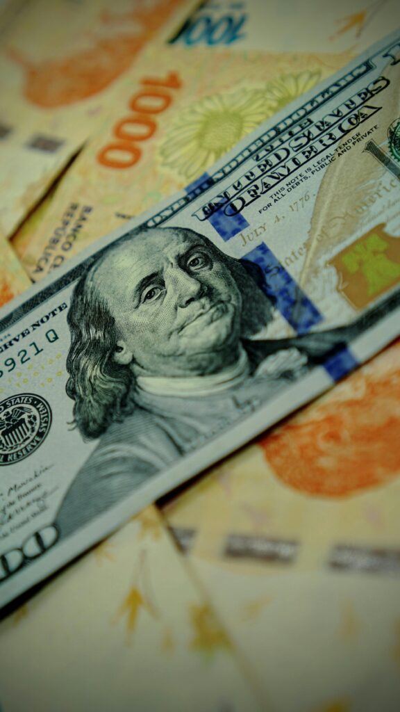 Detailed image of U.S. dollar and Argentine pesos banknotes highlighting currency exchange.